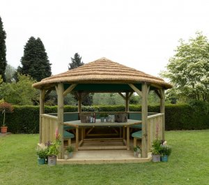Forest Garden 4.7m Hexagonal Wooden Garden Gazebo with Thatched Roof - Furnished with Table, Benches and Cushions (Green)